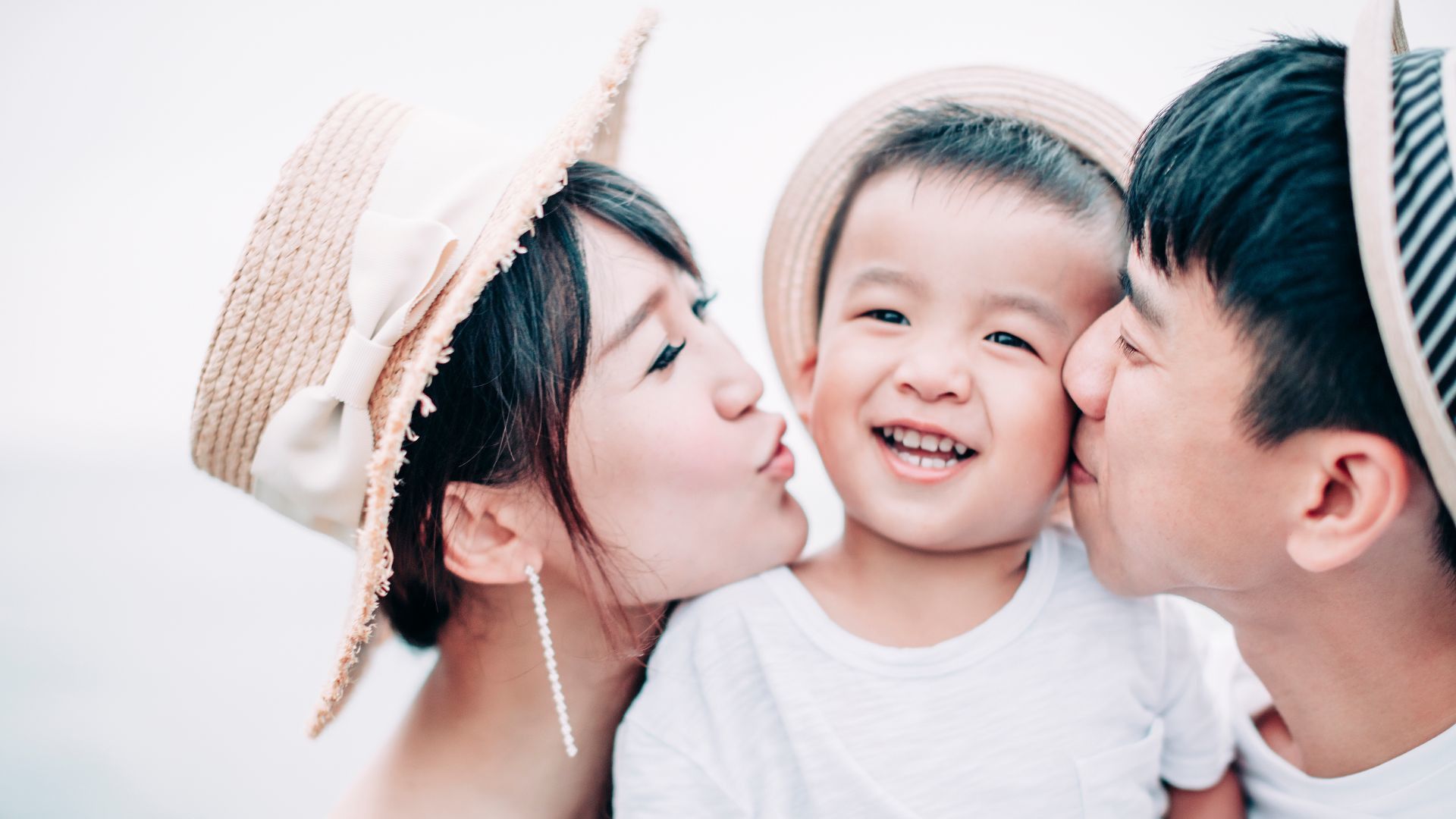 父母親吻嬰兒的臉頰。