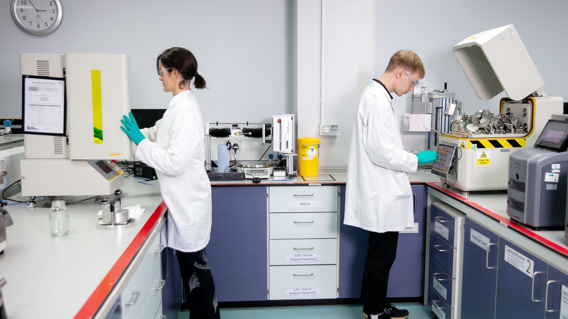 兩位聯合利華包裝材料科學家正在測試樣品，以檢查材料對濕氣、氧氣和光線的阻隔特性。